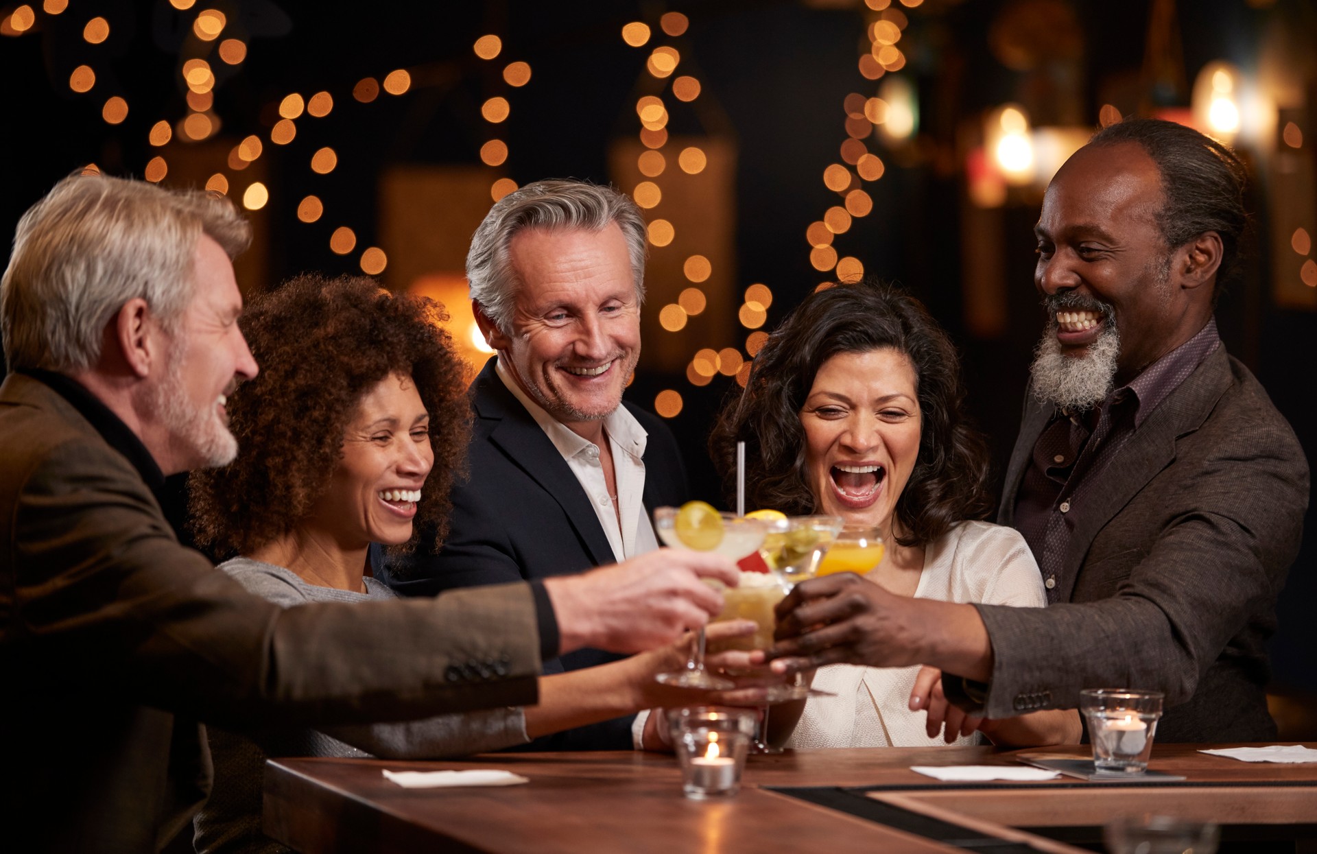 Group Of Middle Aged Friends Celebrating In Bar Together